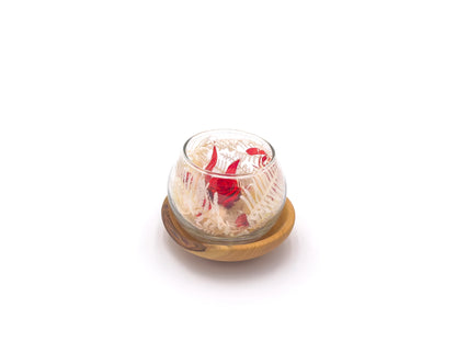 petite bulle en verre contenant une rose eternelle rouge et du feuillage rouge et blanc stabilisés sur un support en bois de genevrier